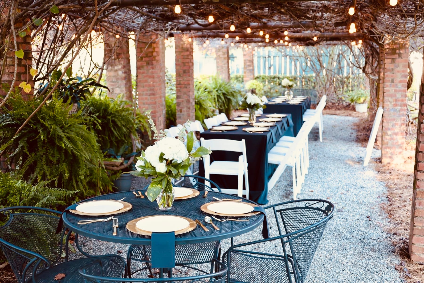 Outdoor courtyard set for dinner under strings of warm lights